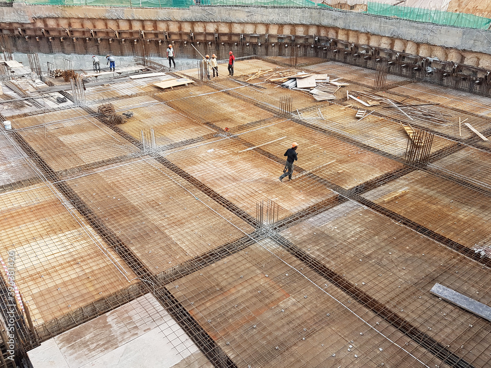 KUALA LUMPUR, MALAYSIA -NOVEMBER 21, 2020: Building floor slab under construction. Construction workers fabricating the timber formwork and installing the steel reinforcement bar. 