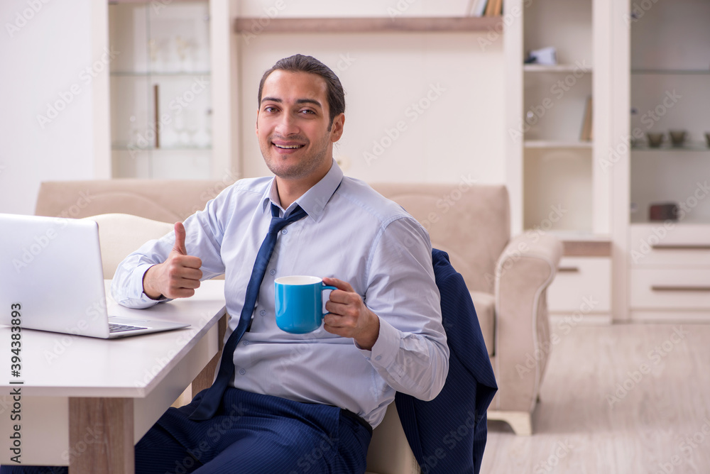 Young male employee working from home in pandemic concept