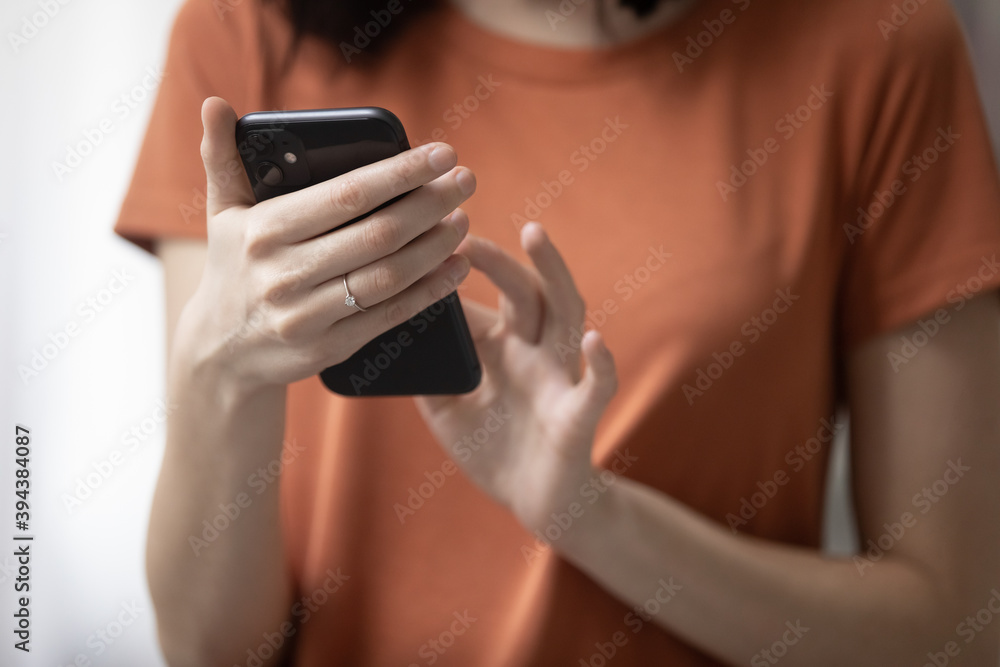 Close up young woman holding smartphone in hands, using mobile software applications, chatting in social networks with friends, scrolling media news feed, shopping online, technology addiction. Close up young woman holding smartphone in hands, using mobile software applications, chatting in social networks with friends, scrolling media news feed, shopping online, technology addiction.