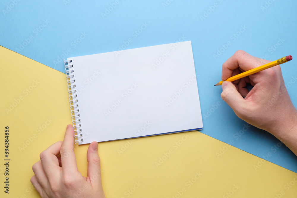 Person makes notes with a pencil in a notebook copy space Person makes notes with a pencil in a notebook copy space