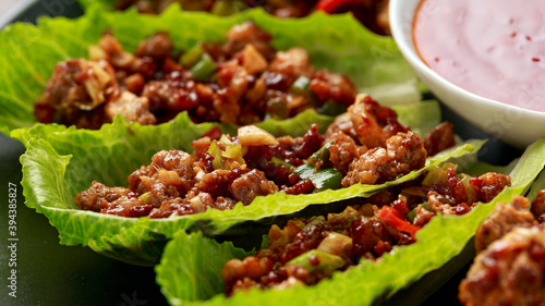 Chilli Beef Lettuce Wraps with sauce on black plate photo