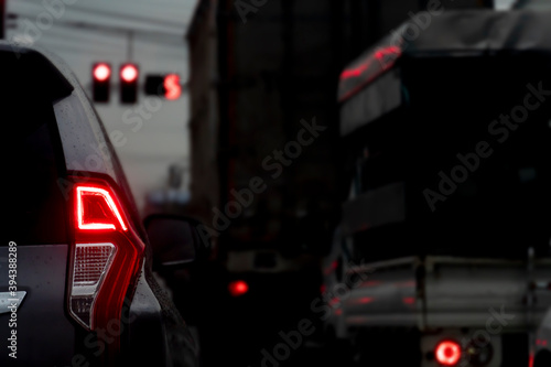 Abstract and Blurred of cars on the road at night with brake light and traffic red light control.