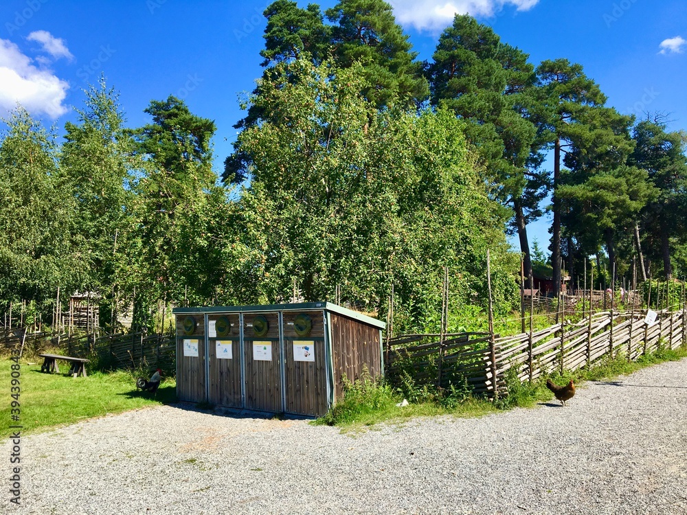 Nice nature with green trees. Some pretty trashcans in front of the picture. Blue sky a hot and warm day. Torekallberget, Sodertalje, Sweden. Nice nature with green trees. Some pretty trashcans in front of the picture. Blue sky a hot and warm day. Torekallberget, Sodertalje, Sweden.