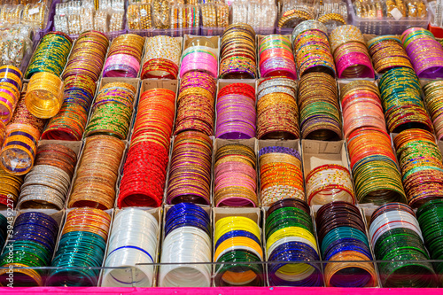 Rows of traditional colorful glass bangles and bracelets are displayed for sale. © Soumen