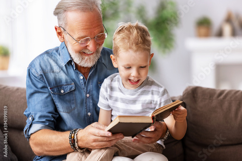 Happy grandfather reading book to grandson.
