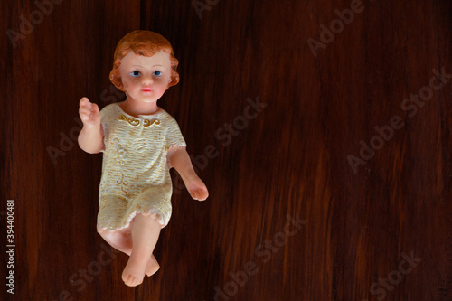 Small statue of Infant Jesus on wooden background, Christmas concept
