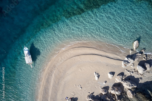 Top view of seashore and boat. Aerial view of motor boat on surface of tropical turquoise ocean coastline.