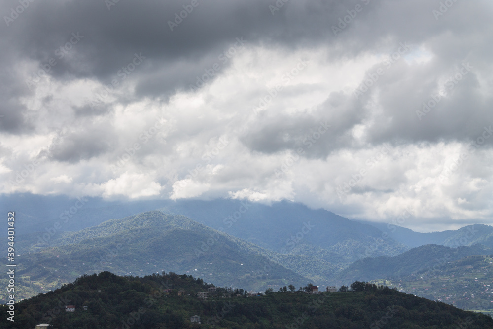 Mountain landscape against the background of black and white clouds. The view from the top.