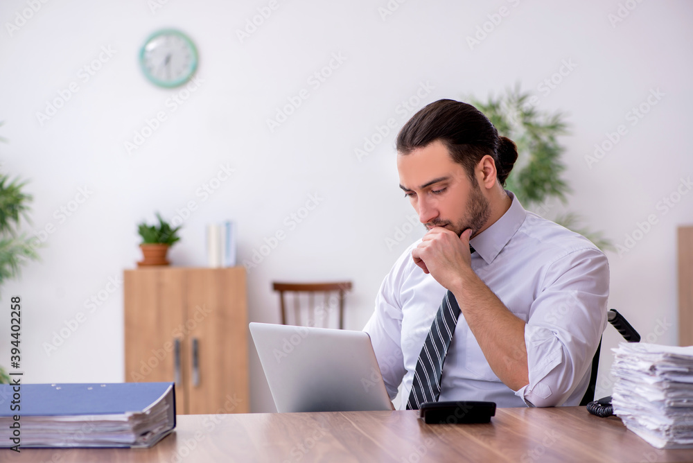 Young disabled employee suffering at workplace Young disabled employee suffering at workplace