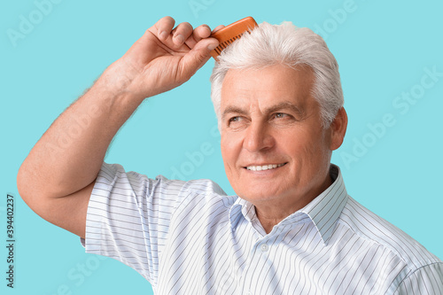 Senior man combing his hair...