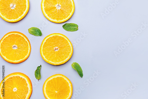 Slices of orange fruit with mint on grey background