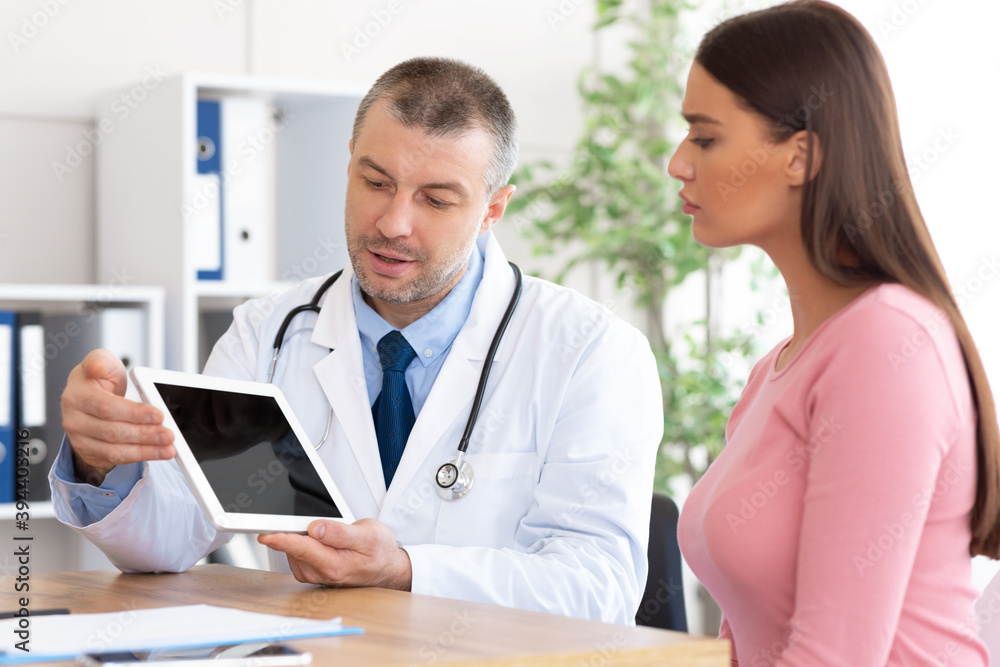 Adult doctor showing patient tablet with black blank screen Adult doctor showing patient tablet with black blank screen