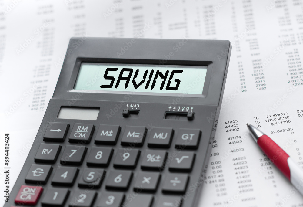 A calculator with the inscription SAVING . Business profit concept A calculator with the inscription SAVING . Business profit concept