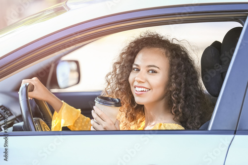 African-American female driver with coffee in car © Pixel-Shot