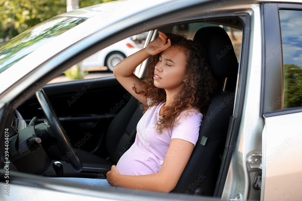 Ill pregnant African-American woman sitting in car Ill pregnant African-American woman sitting in car
