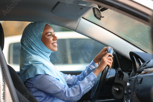 Young Muslim woman driving car