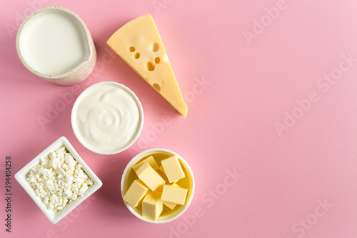 Healthy food most common products from milk are butter, cheese, milk, sour cream, cottage cheese on a pink paper background flat lay with copy space. photo