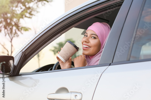 Young Muslim woman drinking...