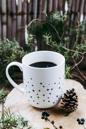 Tasse de café chaud et ambiance d'hiver avec branches de sapin et pomme de pin