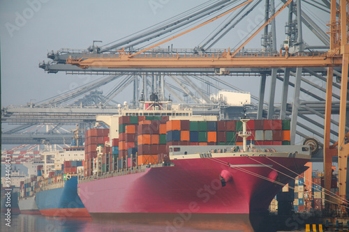 Pink color container ships are entering the commercial port, Logistics and transportation of pink color container Cargo ship and Cargo logistic import export background and transport industry.