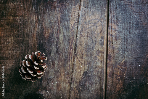 Fond en bois vieilli avec une pomme de pin dans un angle - Arrière plan ambiance saison d'hiver avec espace vide