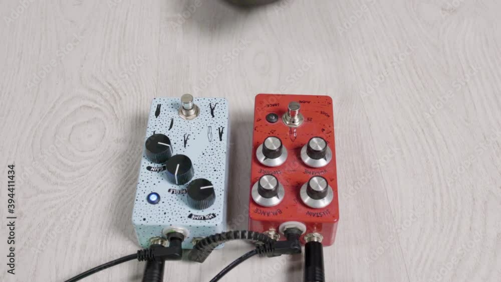 Guitarist presses with his foot on the effects pedals turn on the pedals. Close up of