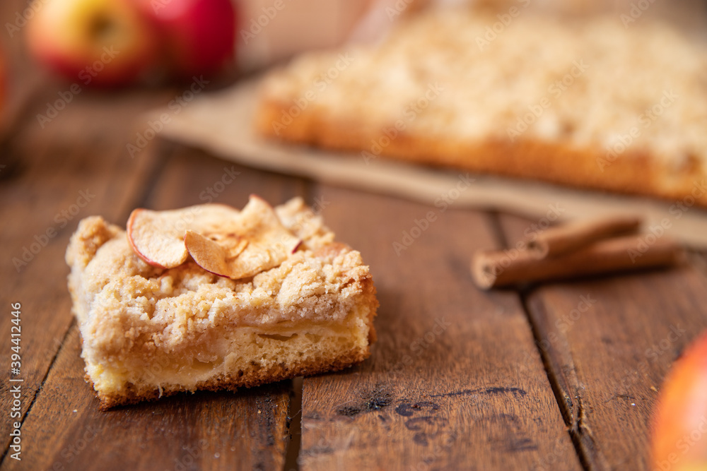 Kuchen mit Äpfeln als Füllung und Streusel auf einem braunen Tisch aus Holz in der Küche Kuchen mit Äpfeln als Füllung und Streusel auf einem braunen Tisch aus Holz in der Küche