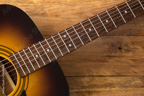 Acoustic guitar on a wooden background.