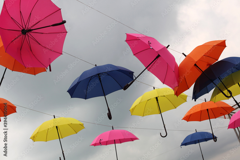 Yellow, pink, blue and red  color umbrellas on sky background.