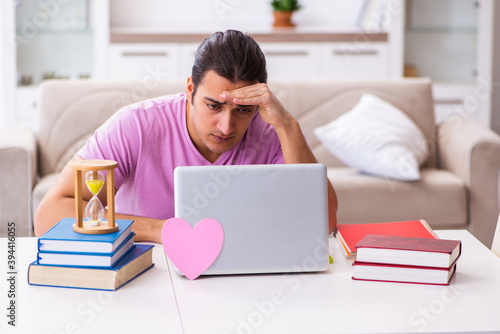 Male student in love preparing for exams in time management conc