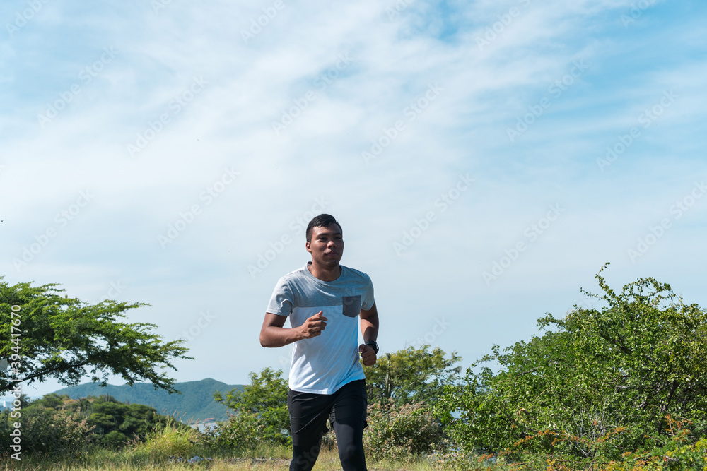 A young African-American man running along a mountain A young African-American man running along a mountain