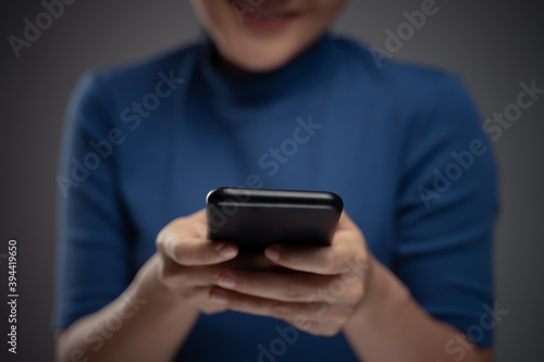 Asian woman happy typing on smart phone.