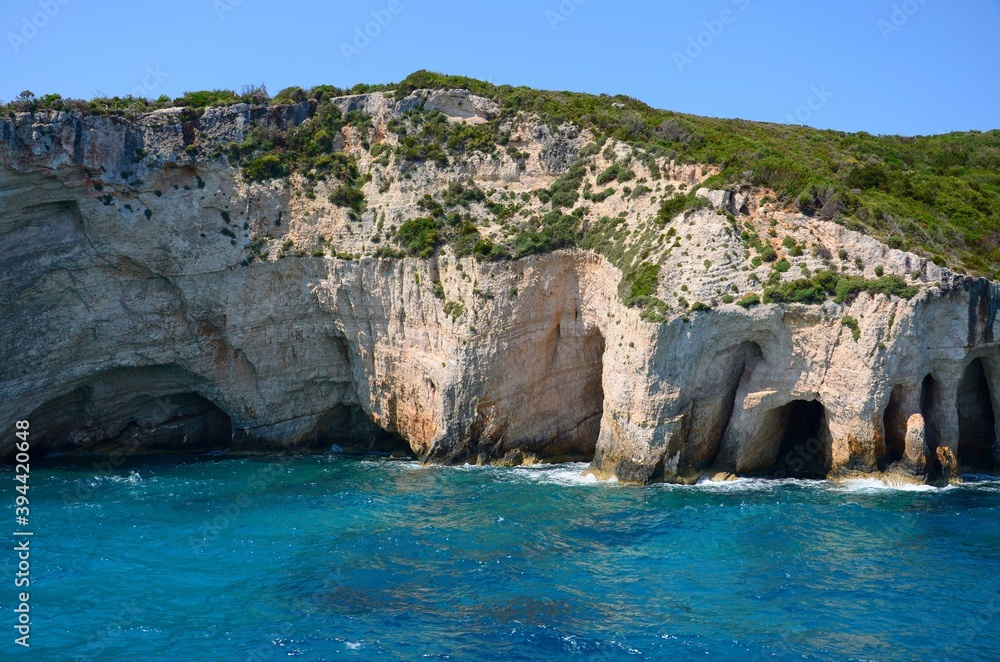 Blue cave on Zakynthos island. Crystal clear water, boat trip around the island of Zakynthos. Caves on the coast created by the sea. Limestone cliffs.