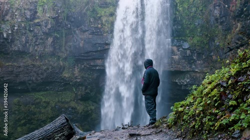 Male stood infront of water fall at henrhyd falls during the winter. South Wales uk. also known for the iconic film batman photo