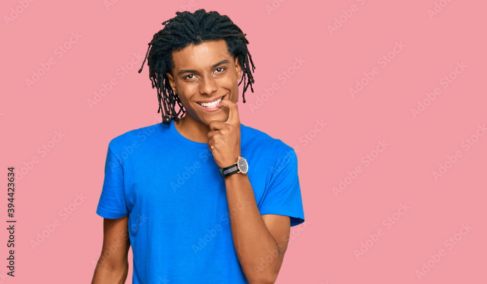 Young african american man wearing casual clothes looking confident at the camera with smile with crossed arms and hand raised on chin. thinking positive. Young african american man wearing casual clothes looking confident at the camera with smile with crossed arms and hand raised on chin. thinking positive.