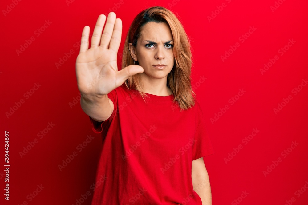 Hispanic young woman wearing casual red t shirt doing stop sing with palm of the hand. warning expression with negative and serious gesture on the face. Hispanic young woman wearing casual red t shirt doing stop sing with palm of the hand. warning expression with negative and serious gesture on the face.