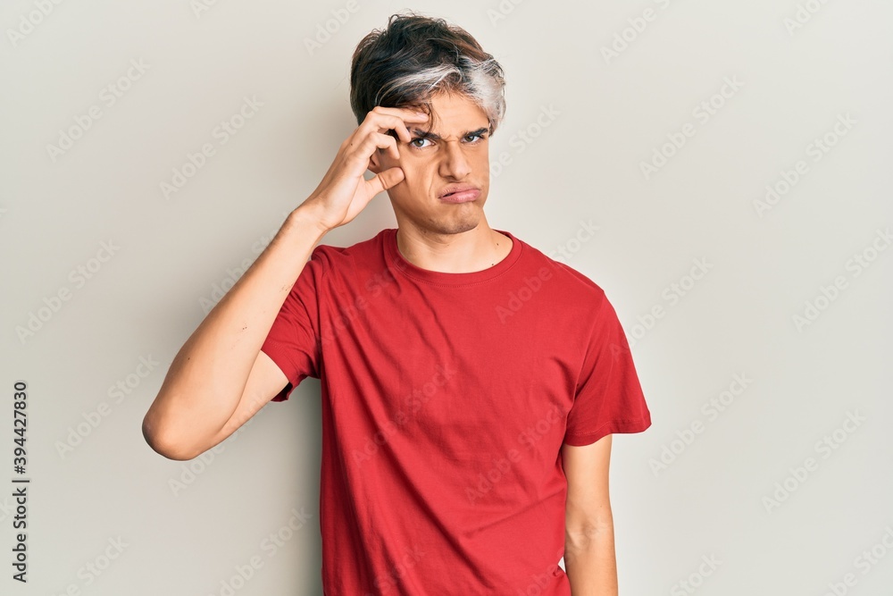 Young hispanic man wearing casual clothes worried and stressed about a problem with hand on forehead, nervous and anxious for crisis Young hispanic man wearing casual clothes worried and stressed about a problem with hand on forehead, nervous and anxious for crisis