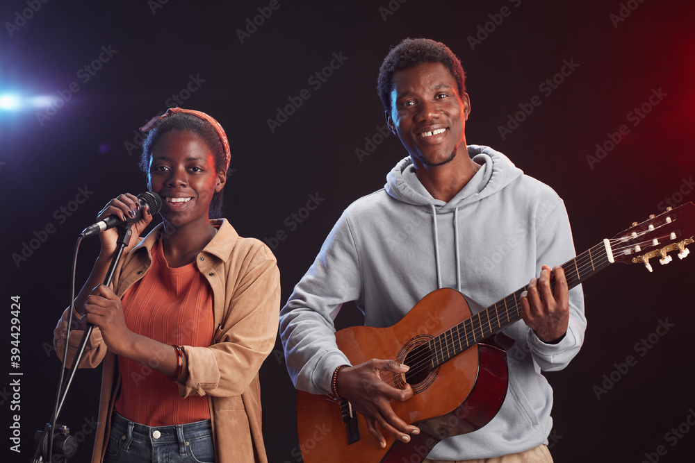 Φωτογραφία Waist up portrait of two African-American musicians playing guitar on stage and