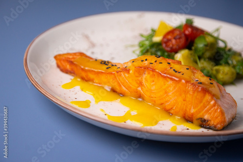 Grilled salmon with orange sauce and gnocchi pesto salad.