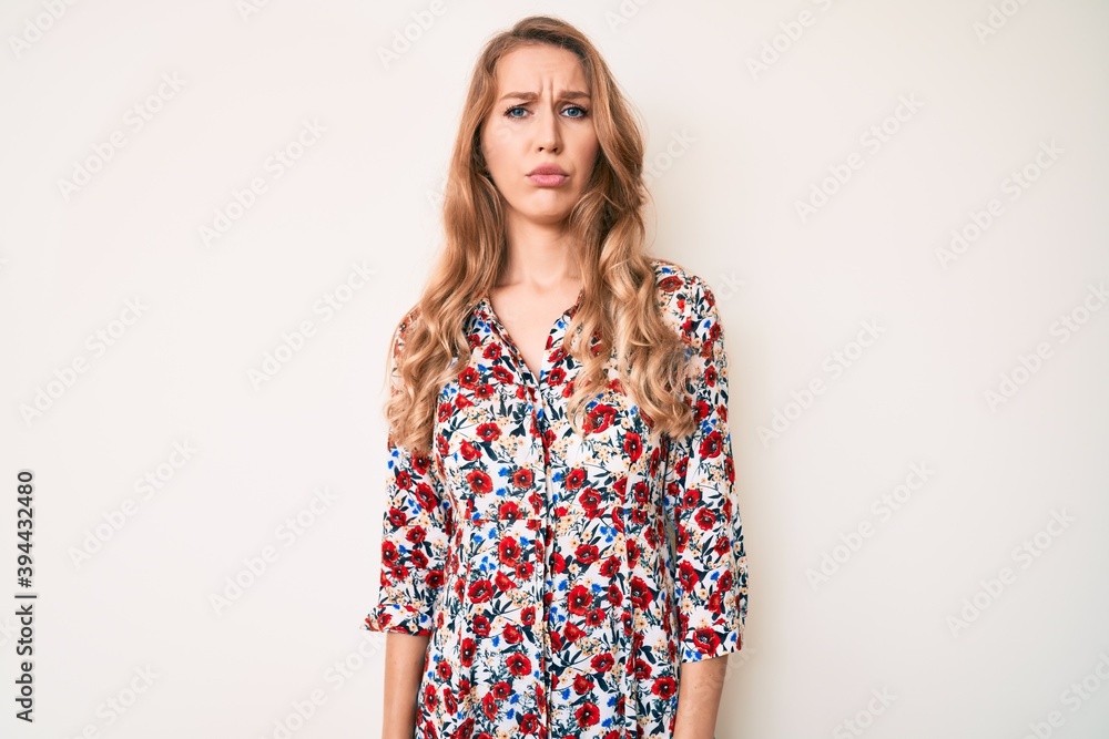 Young caucasian woman with blond hair wearing summer dress skeptic and nervous, frowning upset because of problem. negative person. Young caucasian woman with blond hair wearing summer dress skeptic and nervous, frowning upset because of problem. negative person.