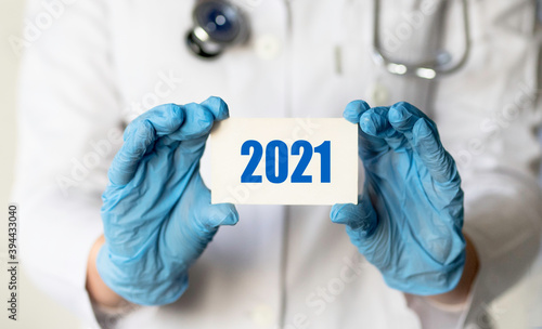 Doctor holding a paper plate text 2021, medical concept