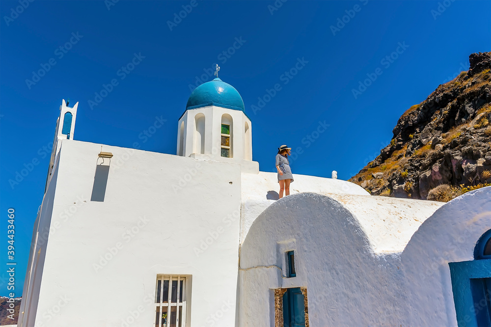 A view towards a blue-domed church on Skaros Rock, Santorini in summertime