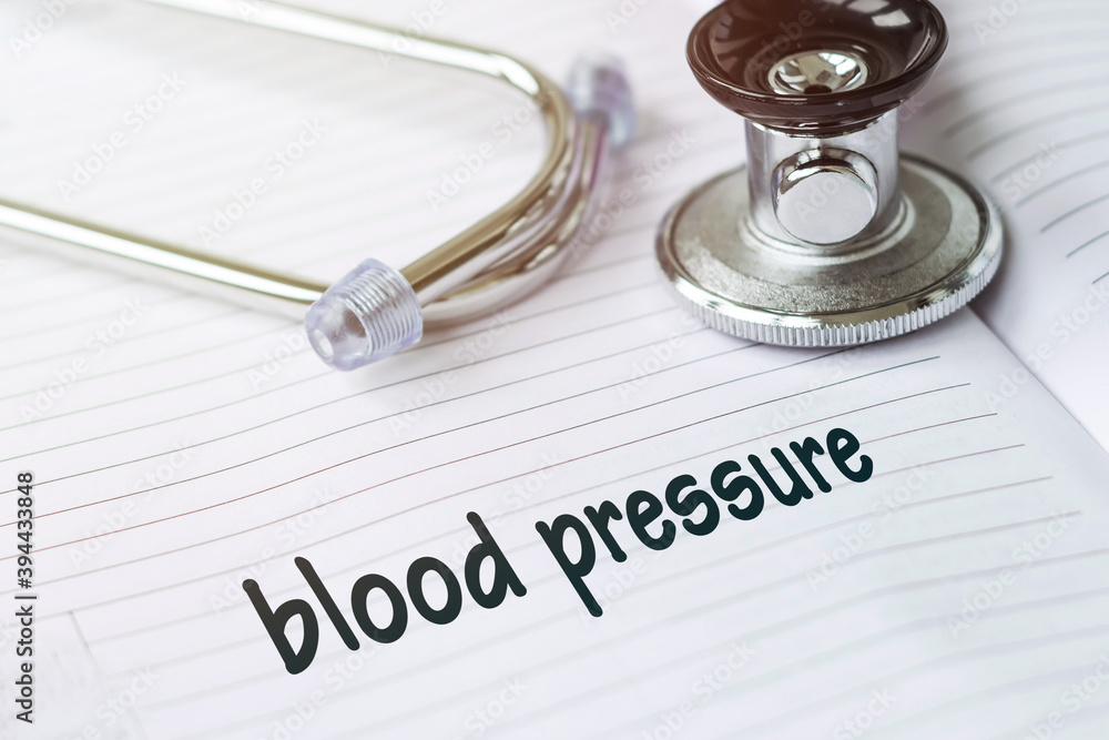 BLOOD PRESSURE. Text on a medical card next to a pen stethoscope. BLOOD PRESSURE. Text on a medical card next to a pen stethoscope.