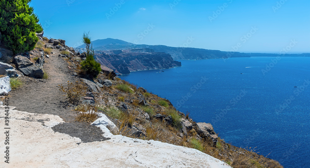 A view of the path from Skaros Rock along the rim of the caldera in Santorini in summertime