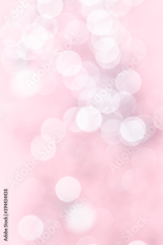 Festive Christmas abstract background. White and gray bokeh lights on pink pastel background.
