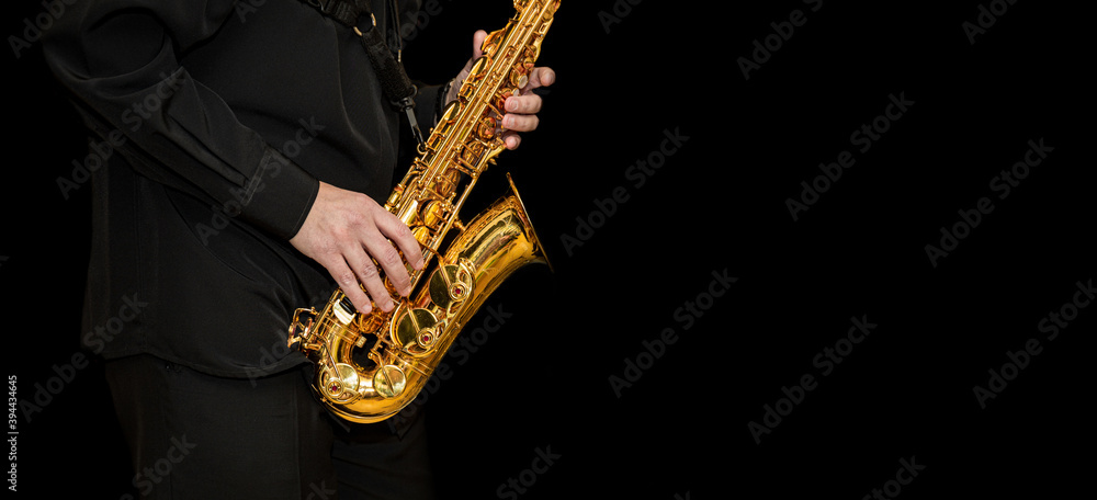Naklejka premium Saxophone with disperse dust effec Player hands Saxophonist playing jazz music. Alto sax musical instrument closeup on black background with place for text