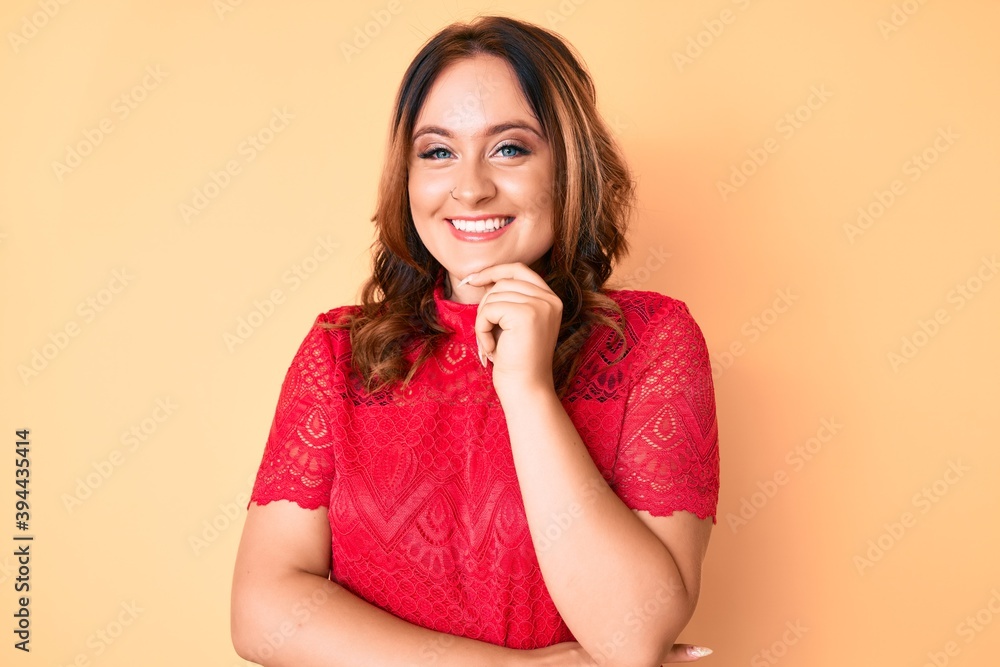 Young beautiful caucasian woman wearing casual clothes looking confident at the camera with smile with crossed arms and hand raised on chin. thinking positive. Young beautiful caucasian woman wearing casual clothes looking confident at the camera with smile with crossed arms and hand raised on chin. thinking positive.