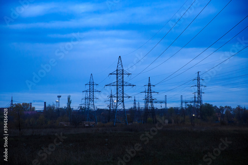 High-voltage lines going to a large substation at dusk