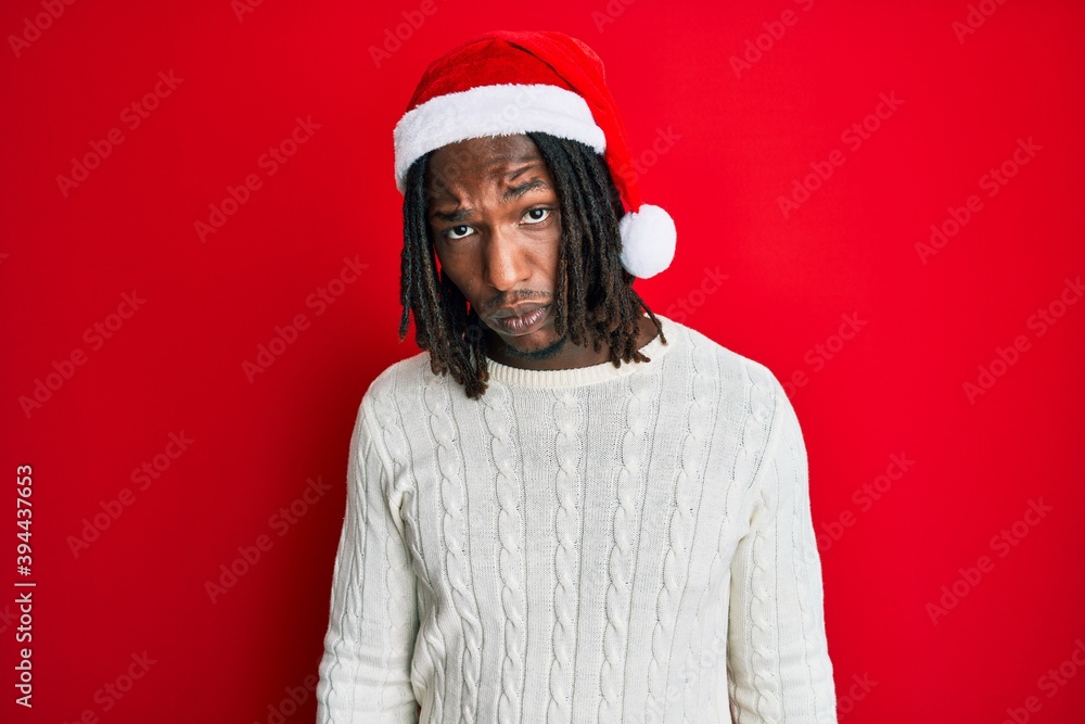 African american man with braids wearing christmas hat skeptic and nervous, frowning upset because of problem. negative person. African american man with braids wearing christmas hat skeptic and nervous, frowning upset because of problem. negative person.