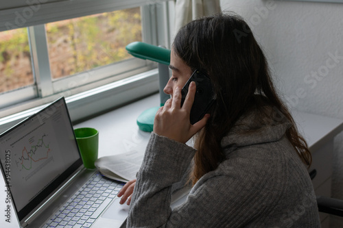 mujer trabajando en casa con un ordenador photo